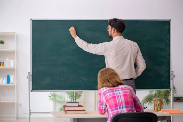 Ung manlig lärare och rödhårig flicka i klassrummet — Stockfoto