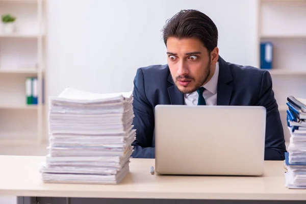 Empleado joven de negocios y demasiado trabajo en la oficina —  Fotos de Stock