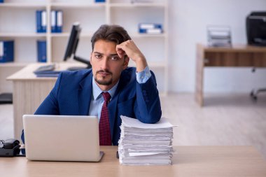 Genç işadamı ve ofiste çok fazla iş var.