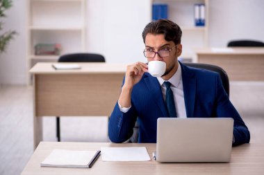 Molada kahve içen genç bir erkek.