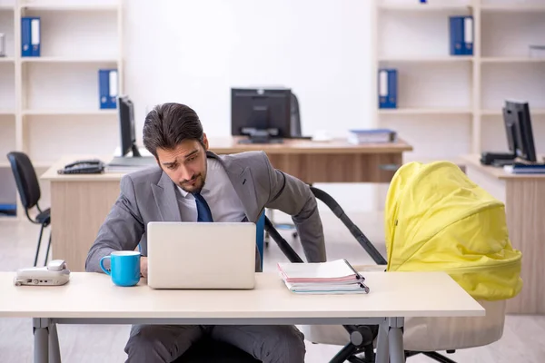 Jeune employé masculin s'occupant d'un nouveau-né sur le lieu de travail — Photo