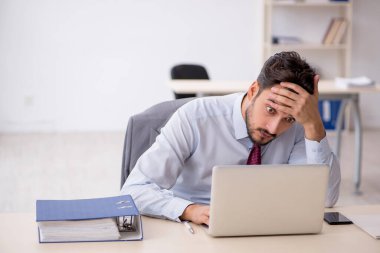 Ofiste çalışan genç bir erkek.