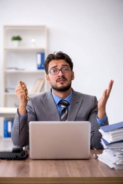 Ofisteki aşırı işten memnun olmayan genç bir erkek işçi.