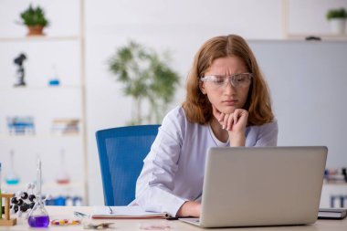 Laboratuarda çalışan genç bir kadın kimyager.