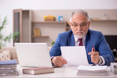 Salgın sırasında evde çalışan yaşlı bir erkek öğretmen.