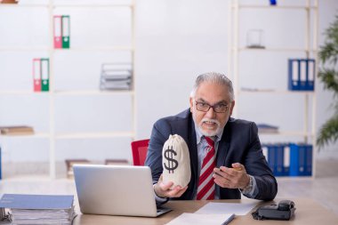 İş yerinde maaş konseptinde çalışan yaşlı bir erkek.