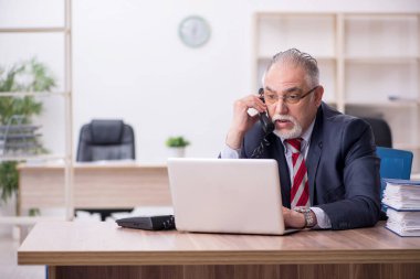 Ofiste çalışan yaşlı bir erkek.