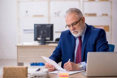 Ofiste çalışan yaşlı bir erkek.