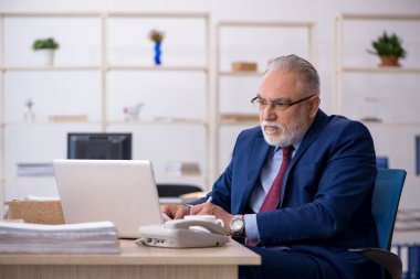 Ofiste çalışan yaşlı bir erkek.