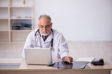 Hastanede çalışan yaşlı bir erkek radyoloji uzmanı.