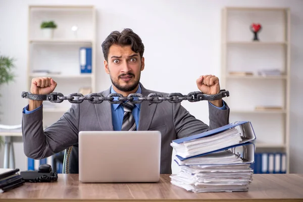 Ung kedjad manlig anställd som sitter på kontoret — Stockfoto