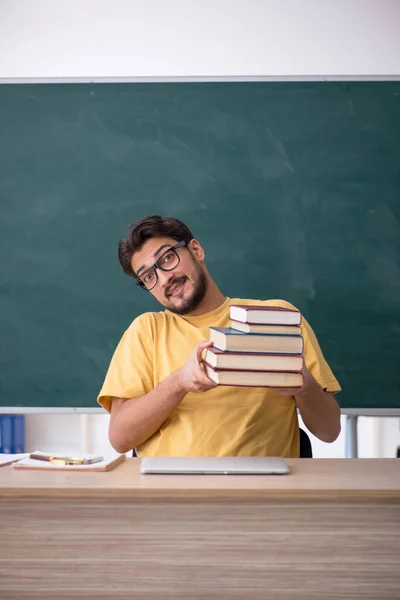 Jonge mannelijke student bereidt zich voor op examens in de klas — Stockfoto