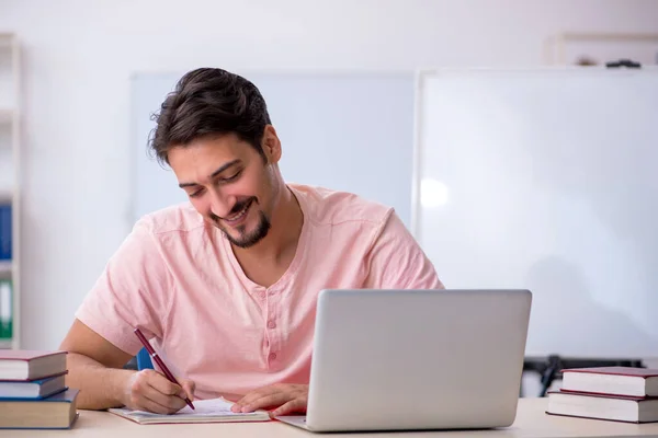 Joven estudiante masculino preparándose para los exámenes en el aula — Foto de Stock