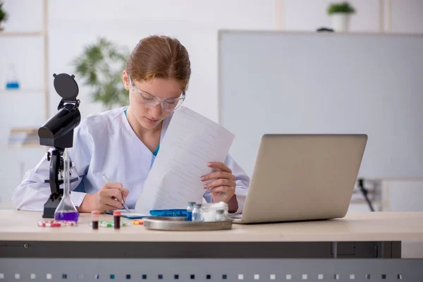 Jonge vrouwelijke chemicus in drugssynthese concept — Stockfoto