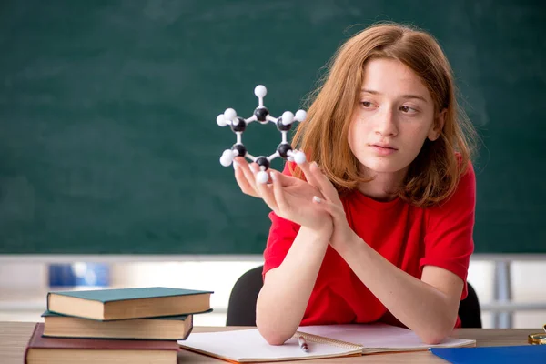 Jonge vrouwelijke student chemicus voorbereiding voor examens in de klas — Stockfoto