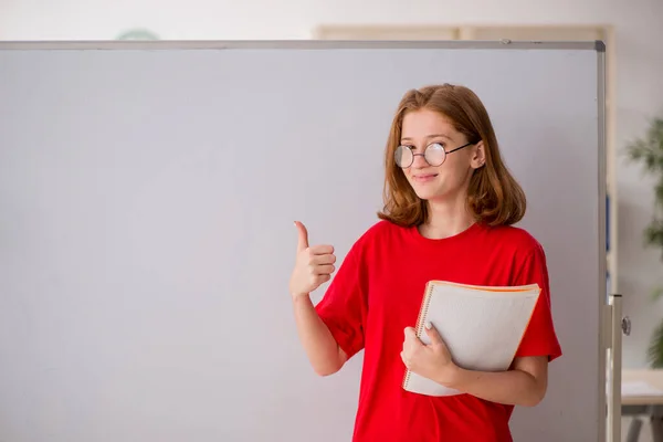 Ung kvinnlig student förbereder sig för tentor i klassrummet — Stockfoto