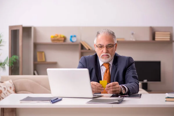 Alte männliche Mitarbeiter arbeiten während der Pandemie von zu Hause aus — Stockfoto