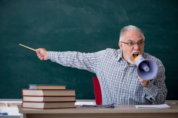 Alter männlicher Lehrer mit Megafon im Klassenzimmer — Stockfoto