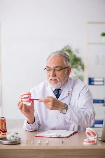 Starý mužský lékař zubař pracující na klinice — Stock fotografie