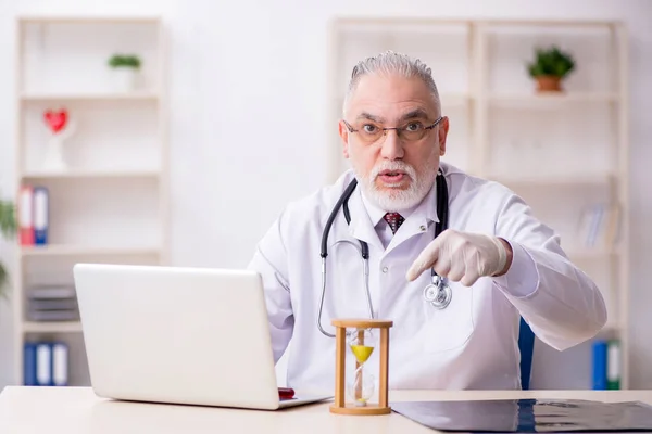 Velho médico masculino no conceito de gerenciamento de tempo — Fotografia de Stock