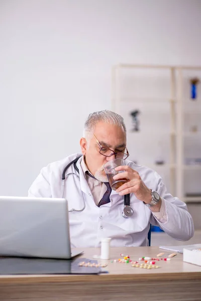 Velho médico do sexo masculino que trabalha no hospital — Fotografia de Stock