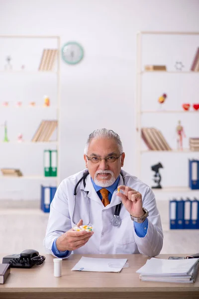 Klinikte çalışan yaşlı erkek doktor. — Stok fotoğraf