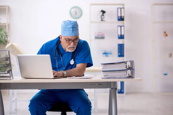 Starý lékař pracující na klinice — Stock fotografie