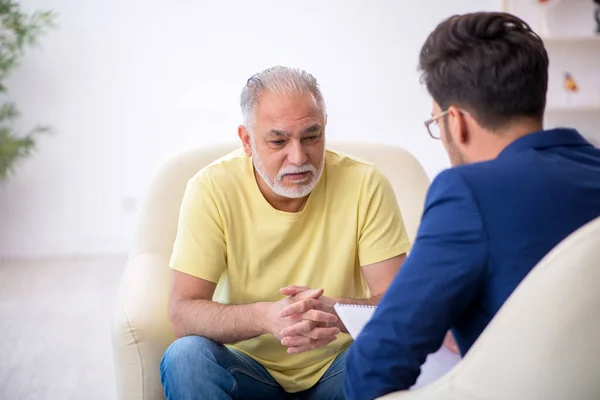 Öreg férfi látogató fiatal férfi pszichoterapeuta — Stock Fotó