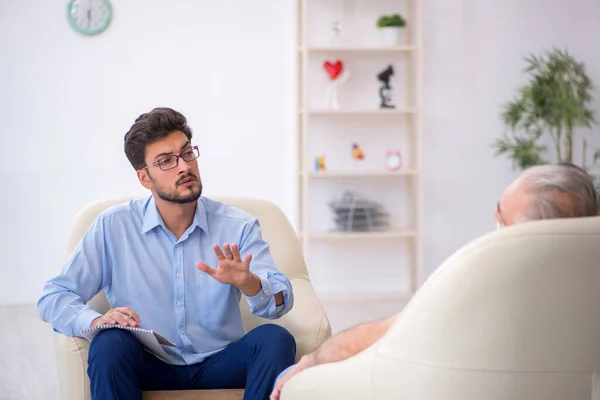 Old man visiting young male psychotherapist — Stock Photo, Image