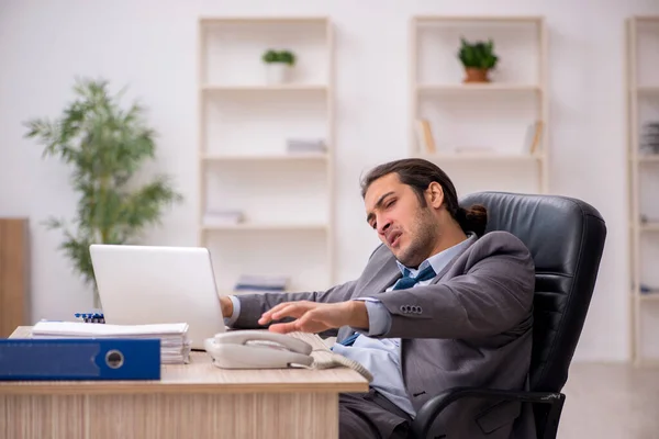 Fiatal férfi alkalmazott elégedetlen a túlzott munka az irodában — Stock Fotó