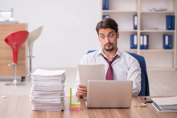 Junge männliche Mitarbeiter und zu viel Arbeit im Büro — Stockfoto