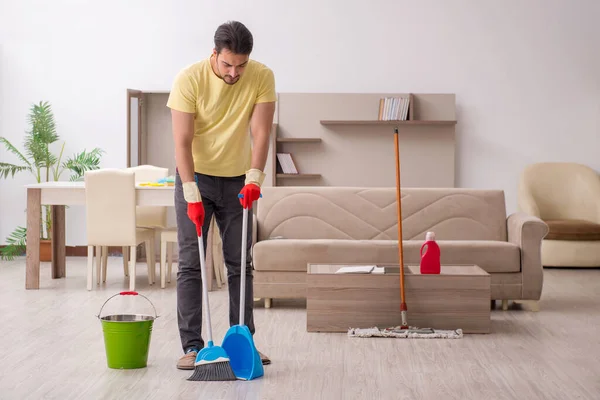 Joven contratista masculino limpiando la casa — Foto de Stock