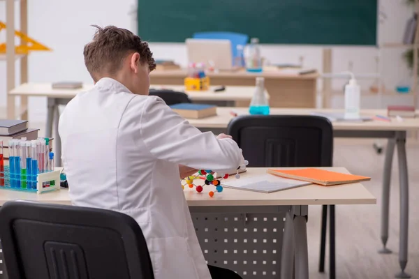 Школьник, изучающий химию в классе — стоковое фото