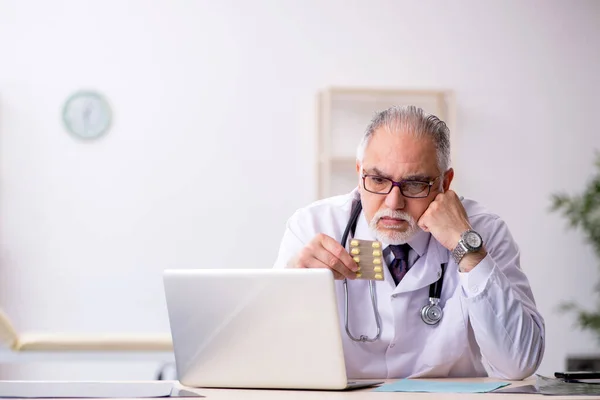 Hastanede çalışan yaşlı erkek doktor. — Stok fotoğraf