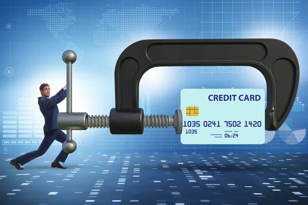 Concept of credit card debt with clamp and businessman — Stock fotografie