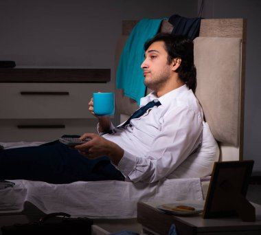 Gece vardiyasından sonra evde çalışan genç bir çalışan.