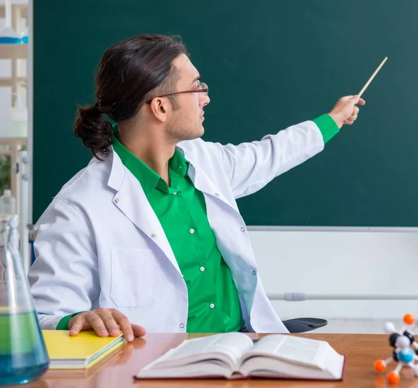 Giovane insegnante di chimica maschile di fronte alla lavagna — Foto Stock