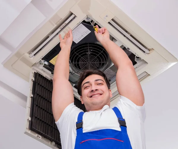 Pracovník opravy stropní klimatizační jednotky — Stock fotografie