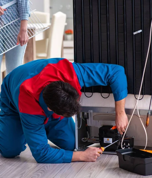 Homem de reparação de geladeira com o cliente — Fotografia de Stock