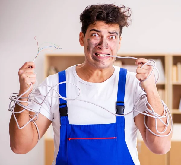 Komik Adam evde elektrik tamiratı yapıyor. — Stok fotoğraf