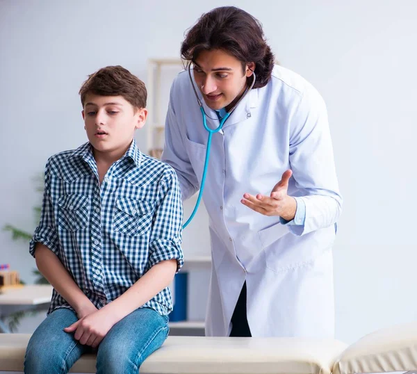 Врач-мужчина осматривает мальчика по стетоскопу — стоковое фото