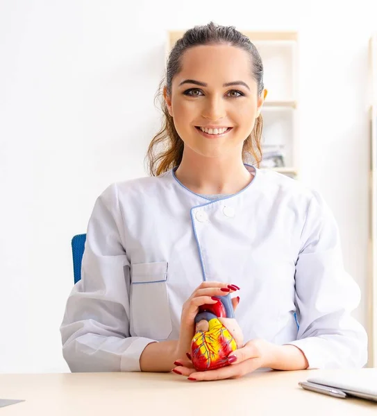 Den unga kvinnliga läkaren kardiolog sitter på sjukhuset — Stockfoto