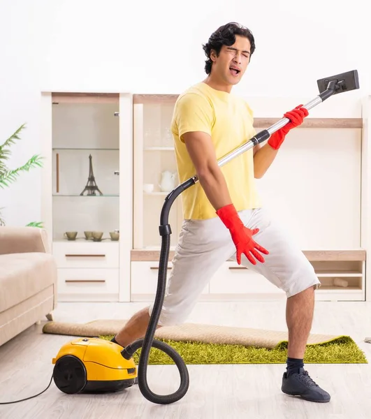 O jovem homem bonito fazendo tarefas domésticas — Fotografia de Stock