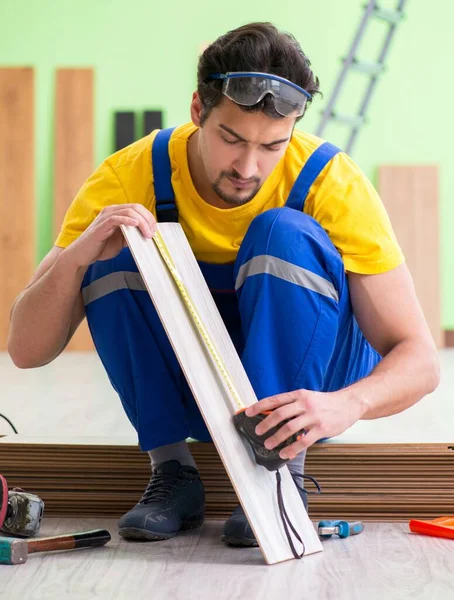 Empreiteiro profissional que coloca piso em casa — Fotografia de Stock