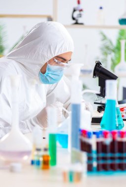 Laboratuvarda kimyasallar üzerinde çalışan genç bir kimyager.