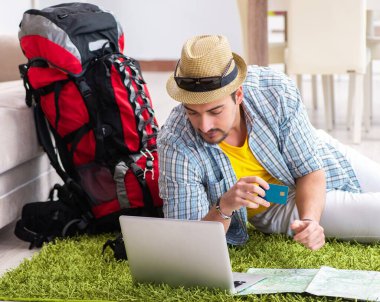 Genç adam internetten seyahat etmeyi planlıyor.