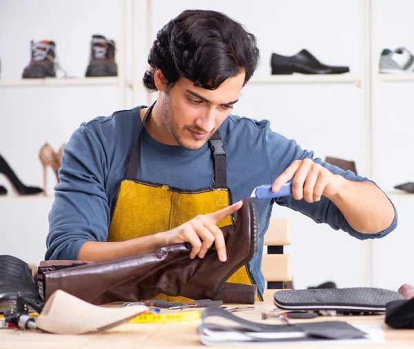 Ο νεαρός επισκευάζει παπούτσια στο εργαστήριο. — Φωτογραφία Αρχείου