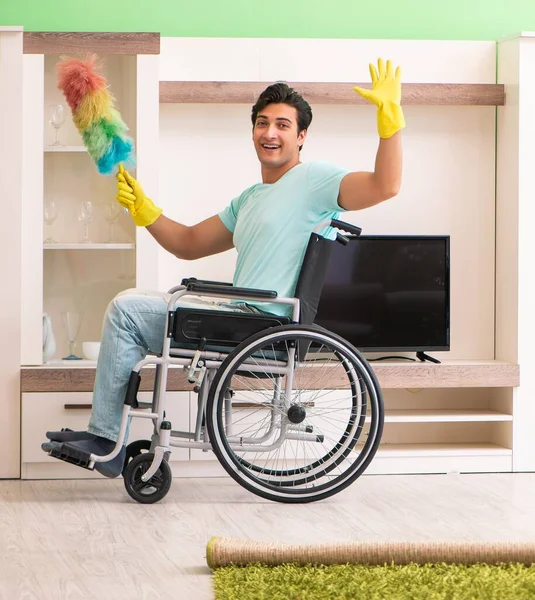 Gehandicapte man op rolstoel schoonmaak huis — Stockfoto