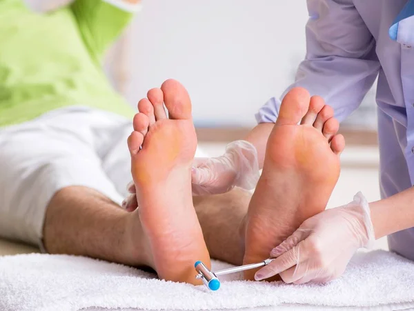 O podólogo que trata pés durante o procedimento — Fotografia de Stock