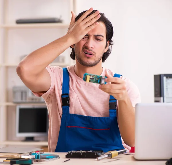 The young male contractor repairing computer — Stock Photo, Image